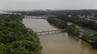 AX74_106 - 4.8K aerial stock footage flying over a footbridge to approach Theodore Roosevelt Memorial Bridge in Washington DC