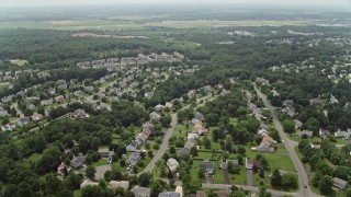 AX74_150E - 4.8K aerial stock footage flying over ponds to approach Prince William County Fairgrounds by suburban homes in Manassas, Virginia