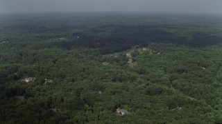 4.8K aerial stock footage flying over forest, approaching upscale homes, Clifton, Virginia Aerial Stock Footage | AX75_008E