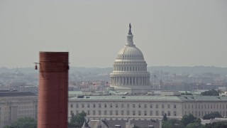 4.8K aerial stock footage of United States Capitol dome visible above office building rooftops in Washington DC Aerial Stock Footage | AX75_053E