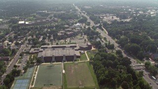 AX75_140E - 4.8K aerial stock footage flying over suburban homes to approach an elementary school and government office buildings in Arlington, Virginia