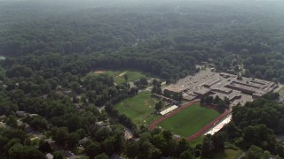 AX75_145E - 4.8K aerial stock footage flying over Stuart High School beside Lake Barcroft in Falls Church, Virginia