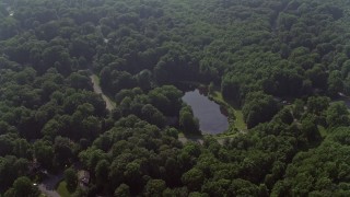 4.8K aerial stock footage of homes by pond on Havenner Road, surrounded by forest in Fairfax Station, Virginia Aerial Stock Footage | AX75_165