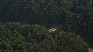 4.8K aerial stock footage flying by Yates Ford Road bridge, partially hidden in forest, Clifton, Virginia, sunset Aerial Stock Footage | AX76_009