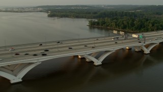 4.8K aerial stock footage of cars crossing Woodrow Wilson Memorial Bridge, Potomac River, Fort Washington, Maryland, sunset Aerial Stock Footage | AX76_033