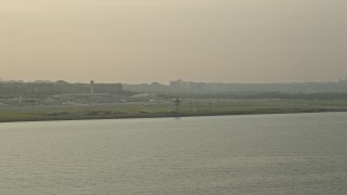 AX76_037 - 4.8K aerial stock footage flying by Ronald Reagan Washington National Airport, Arlington, Virginia, sunset