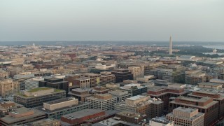 AX76_076 - 4.8K aerial stock footage of Washington Monument and Jefferson Memorial from over buildings, Washington D.C., sunset