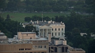 AX76_077 - 4.8K aerial stock footage flying by The White House, reveal North Lawn Fountain, Washington D.C., sunset