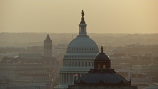 AX76_090E - 4.8K aerial stock footage of the United States Capitol and Thomas Jefferson Building domes, Washington D.C., sunset