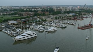 AX76_134 - 4.8K aerial stock footage of Yachts docked at Gangplank Marina, Washington, D.C., twilight