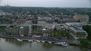 AX76_155 - 4.8K aerial stock footage of a water and light show at Washington Harbour, Washington, D.C., twilight