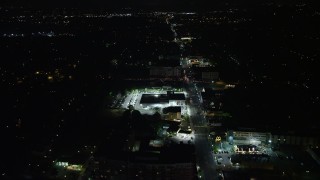 4.8K aerial stock footage following Columbia Pike to approach a car dealership and shops in Arlington, Virginia, night Aerial Stock Footage | AX77_074E