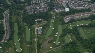 AX78_040E - 4.8K aerial stock footage of a reverse view of tract homes, revealing Trump National Golf Club, Sterling, Virginia