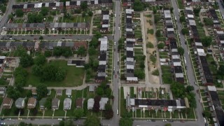 AX78_122 - 4.8K aerial stock footage tilting from urban row houses, tilt up revealing Herring Run Park, public housing in Baltimore, Maryland