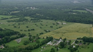 AX78_136E - 4.8K aerial stock footage flying over golf course to approach power lines in Kingsville, Maryland