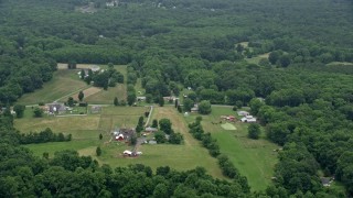 AX78_139E - 4.8K aerial stock footage flying over rural homes, farms, and barns in Joppa, Maryland