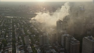 AX80_035E - 4.8K aerial stock footage of residential fire near office buildings in Downtown Philadelphia, Pennsylvania, Sunset