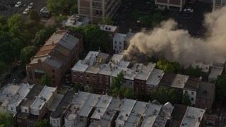 4.8K aerial stock footage of a reverse view of a residential fire near Downtown Philadelphia, Pennsylvania, Sunset Aerial Stock Footage | AX80_041