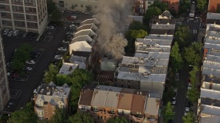 4.8K aerial stock footage tracking a residential fire near Downtown Philadelphia, Pennsylvania, Sunset Aerial Stock Footage | AX80_043