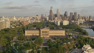 AX80_054E - 4.8K aerial stock footage panning across the Schuylkill River to reveal Boathouse Row, Museum of Art, City Hall, and skyscrapers, Philadelphia, Pennsylvania, Sunset