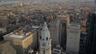 4.8K aerial stock footage approaching the William Penn statue atop City Hall in Downtown Philadelphia, Pennsylvania, Sunset Aerial Stock Footage | AX80_057E