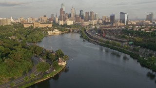 AX80_065E - 4.8K aerial stock footage of Downtown Philadelphia skyline seen from Boathouse Row and the the Schuylkill River, Pennsylvania, Sunset