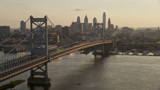 AX80_075E - 4.8K aerial stock footage of Benjamin Franklin Bridge and Downtown Philadelphia skyline, Pennsylvania, Sunset