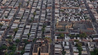 AX80_108 - 4.8K aerial stock footage of an urban neighborhood around St. Thomas Aquinas Church, South Philadelphia, Pennsylvania Sunset