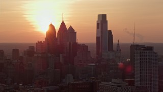 4.8K aerial stock footage of the setting sun behind the Downtown Philadelphia skyline, Pennsylvania, Sunset Aerial Stock Footage | AX80_130E