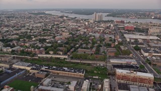 4.8K aerial stock footage of row houses by railroad tracks and Edgar Allan Poe House in North Philadelphia, Pennsylvania, Sunset Aerial Stock Footage | AX80_145