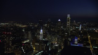 AX81_040E - 4.8K aerial stock footage fly away from Philadelphia City Hall to reveal Downtown Philadelphia skyscrapers, Pennsylvania, Night