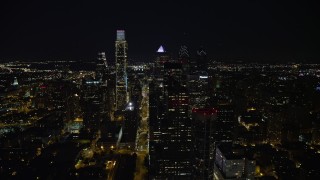 4.8K aerial stock footage following John F Kennedy Boulevard to approach Downtown Philadelphia skyscrapers, reveal city hall, Pennsylvania, Night Aerial Stock Footage | AX81_053E