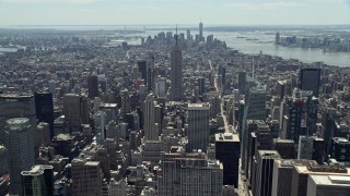 4.8K aerial stock footage flying over Midtown Manhattan skyscrapers to approach the Empire State Building, New York City Aerial Stock Footage | AX83_119E