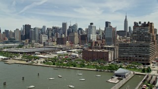 4.8K aerial stock footage flying by Starrett-Lehigh Building and Hudson Yards, land at heliport, with a view of Midtown Manhattan skyscrapers, New York City Aerial Stock Footage | AX83_151E