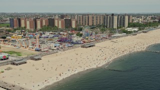 AX83_212E - 4.8K aerial stock footage flying over beach goers on Coney Island Beach to approach Luna Park, Brooklyn, New York City