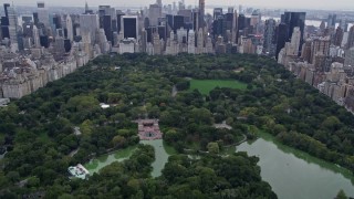 4K aerial stock footage tilt from Central Park, reveal and approach Midtown skyscrapers, New York City Aerial Stock Footage | AX84_044E