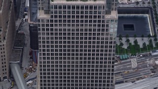 4K aerial stock footage tilt down the side of Freedom Tower, reveal the Memorial in Lower Manhattan, New York City Aerial Stock Footage | AX84_091E