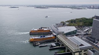 4K aerial stock footage approaching Staten Island Ferries by Lower Manhattan skyscrapers, New York City Aerial Stock Footage | AX84_108E