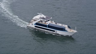 4K aerial stock footage of a ferry on Hudson River, tilt to reveal Lower Manhattan skyscrapers, New York City Aerial Stock Footage | AX84_110E