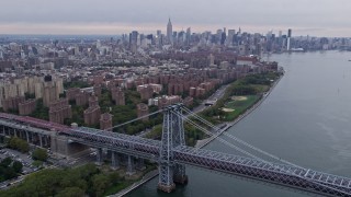 AX84_124E - 4K aerial stock footage tilt from Brooklyn Navy Yard piers, approach Williamsburg Bridge and Lower East Side, New York City