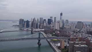 AX84_153E - 4K aerial stock footage tilt from Lower East Side to reveal Lower Manhattan skyline, Brooklyn and Manhattan Bridges, New York City