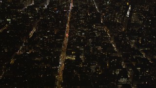 4K aerial stock footage Tilting up from streets, reveal Midtown Manhattan, New York, New York, night Aerial Stock Footage | AX85_033