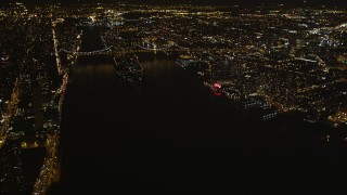 4K aerial stock footage Tilt up from East River, revealing Queensboro Bridge, New York, New York, night Aerial Stock Footage | AX85_060