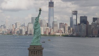 4K aerial stock footage Flying by Statue of Liberty, revealing Lower Manhattan skyline, New York, New York Aerial Stock Footage | AX87_011