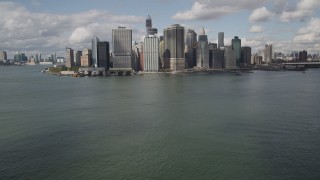 4K aerial stock footage Tilt up from bay to reveal Lower Manhattan skyscrapers, New York, New York Aerial Stock Footage | AX87_046