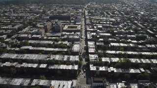 4K aerial stock footage of following a street past row houses near 8th Avenue Armory, Brooklyn, New York Aerial Stock Footage | AX88_019