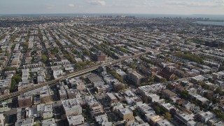 4K aerial stock footage of flying over row houses, tilt to railroad tracks, Brooklyn, New York Aerial Stock Footage | AX88_033