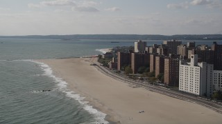 4K aerial stock footage of flying by Coney Island Beach and apartment buildings in Brooklyn, New York, New York Aerial Stock Footage | AX88_051