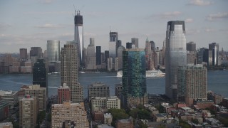 AX88_173 - 4K aerial stock footage of cruise ship passing Lower Manhattan skyscrapers, seen from Downtown Jersey City, New Jersey