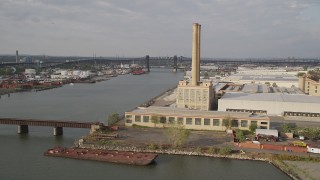 4K aerial stock footage of approaching a factory with smoke stacks and warehouses, Kearny, New Jersey Aerial Stock Footage | AX88_203